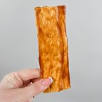 6"x2" flat Collagen dog chew being held by a female hand