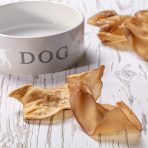 Ceramic Dog Bowl, with Dog written on it, with Dried Cows Ear treats surrounding it