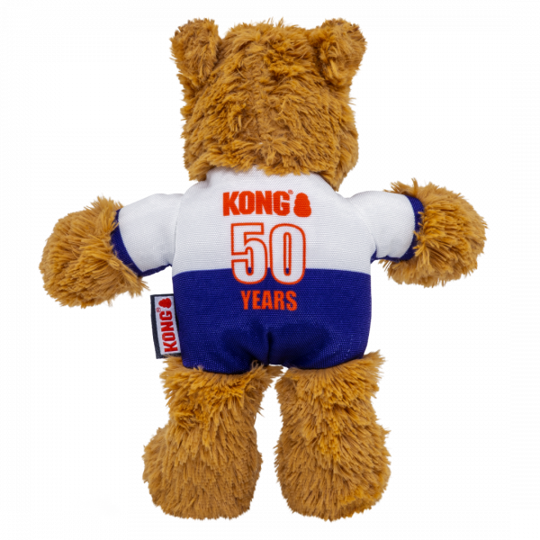KONG Wild Knots World Cup England Bear Back 1080px The back view of the KONG Wild Knots England Bear showing the white and blue football jersey. The reverse of the shirt is printed with the orange "KONG 50 YEARS" commemorative logo, celebrating the brand's milestone. A small woven KONG brand tag is visible on the left side. The image highlights the soft, textured brown fur and the quality construction of the limited edition commemorative toy.