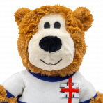 A detailed close-up shot of the KONG Wild Knots England Bear's face and upper chest. The bear features an off-white muzzle, a large black plush nose, and small stitched eyes that are safe for pets. The St George’s Cross patch on the white football shirt is clearly visible with detailed black "stitch" accents. The image showcases the high-quality, shaggy brown plush fabric used throughout the toy.