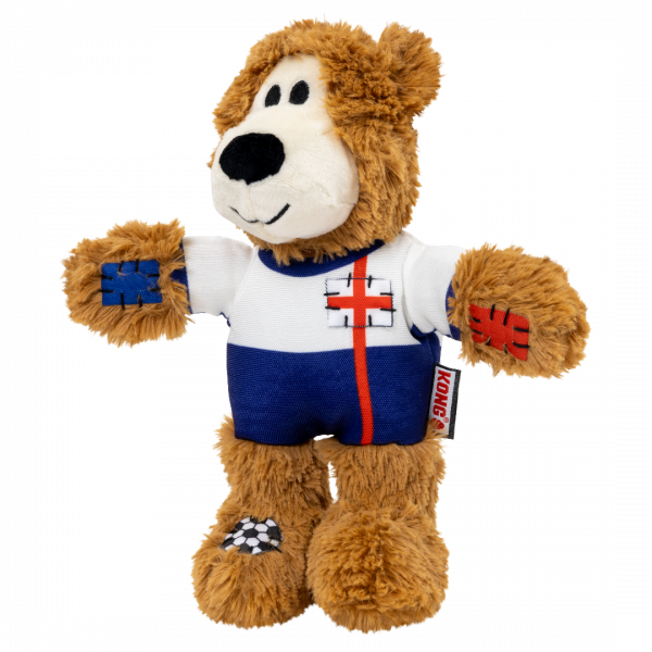 KONG Wild Knots World Cup England Bear Face Left 1080px A three-quarter side view of the KONG Wild Knots England Bear facing left. The pose highlights the toy's soft limbs and durable football jersey. The red St George's Cross stripe extends down the side of the blue "shorts" section of the kit. The shaggy ears and sturdy plush body are clearly visible, illustrating the bear's friendly appearance and play-ready design.