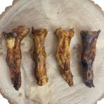 Four Large Ostrich Feet arranged on a wooden slice – natural hypoallergenic long lasting dog chews rich in protein and calcium