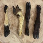 4 Nova Dog Chews Hairy Lamb Legs on a wooden display plinth