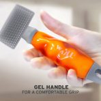 Close-up of a hand squeezing the soft, ergonomic orange gel handle of the WAHL pet brush, demonstrating its comfortable, pressure-relieving grip. Text overlay at the bottom reads: "GEL HANDLE FOR A COMFORTABLE GRIP"
