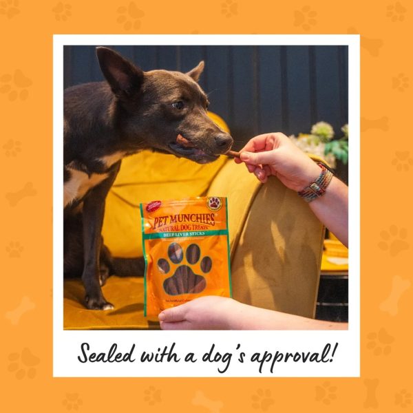 pet-munchies-beef-liver-sticks-dog-treats-90g-4 Dog taking a Pet Munchies beef liver stick from an owner's hand, with the pack in front